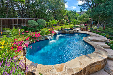 Hot tub - mid-sized traditional backyard custom-shaped and stone natural hot tub idea in Austin