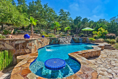 Example of a mid-sized classic backyard stone and custom-shaped natural pool fountain design in Austin