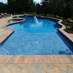 Diseño de piscina con fuente clásica, de tamaño medio, a medida, en patio trasero, con adoquines de hormigón