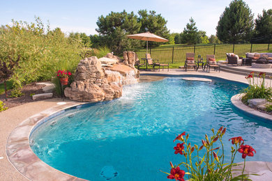 Imagen de piscina con fuente natural tradicional de tamaño medio a medida en patio trasero