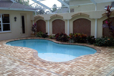 Imagen de casa de la piscina y piscina de estilo americano a medida en patio trasero con adoquines de ladrillo