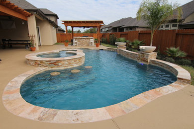Backyard custom-shaped pool fountain photo in Houston with decking