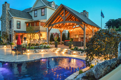 Esempio di una grande piscina naturale stile rurale personalizzata dietro casa con paesaggistica bordo piscina e pavimentazioni in pietra naturale