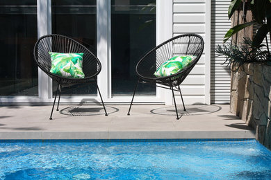 Foto de casa de la piscina y piscina costera rectangular en patio trasero con adoquines de piedra natural