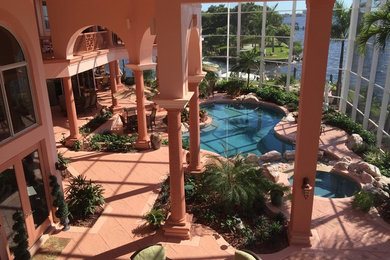 Modelo de piscinas y jacuzzis naturales mediterráneos extra grandes a medida en patio trasero con adoquines de hormigón