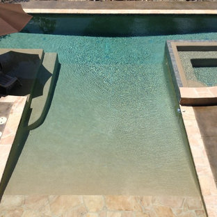 Ispirazione per una grande piscina monocorsia moderna personalizzata dietro casa con una vasca idromassaggio e pedane