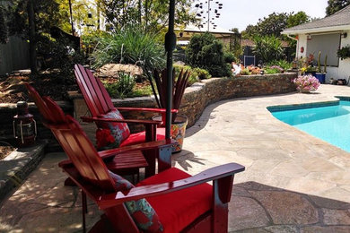 Inspiration for a mid-sized timeless backyard stone and custom-shaped pool remodel in Orange County