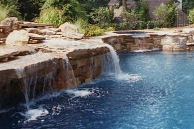 Imagen de piscina grande en patio trasero con adoquines de piedra natural