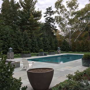 Modelo de piscinas y jacuzzis alargados, clásicos renovados, de tamaño medio, rectangulares, en patio trasero, con adoquines de piedra natural