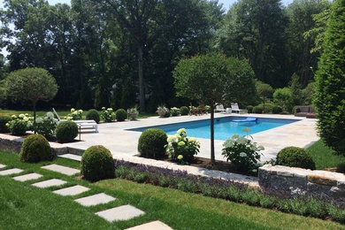 Modelo de piscina alargada contemporánea de tamaño medio rectangular en patio trasero con adoquines de piedra natural