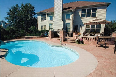 Ejemplo de piscina clásica renovada a medida en patio trasero con adoquines de ladrillo