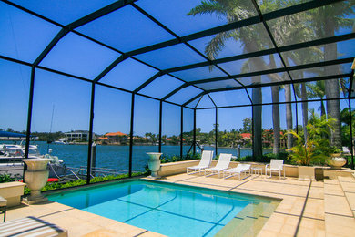 Imagen de casa de la piscina y piscina tropical grande a medida y interior con adoquines de ladrillo