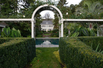 Modelo de casa de la piscina y piscina alargada clásica grande rectangular en patio trasero con adoquines de piedra natural