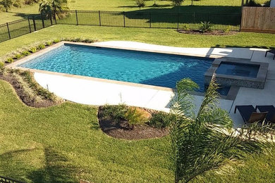 Diseño de piscinas y jacuzzis alargados tradicionales grandes rectangulares en patio trasero con losas de hormigón