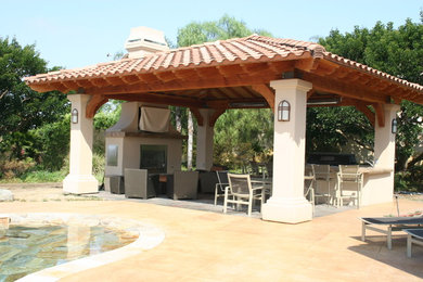 Diseño de patio mediterráneo de tamaño medio en patio trasero con losas de hormigón