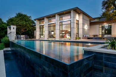 Pool - contemporary backyard tile and custom-shaped infinity pool idea in Austin