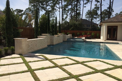 Mid-sized trendy backyard stone and custom-shaped hot tub photo in Houston