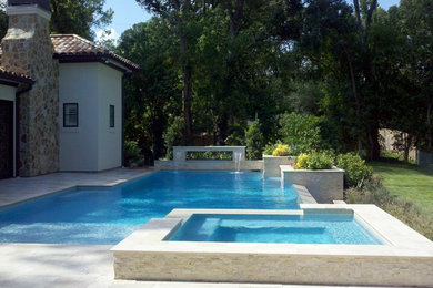 Mid-sized trendy backyard stone and custom-shaped infinity hot tub photo in Houston