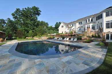 Large elegant backyard tile and rectangular lap pool house photo in New York
