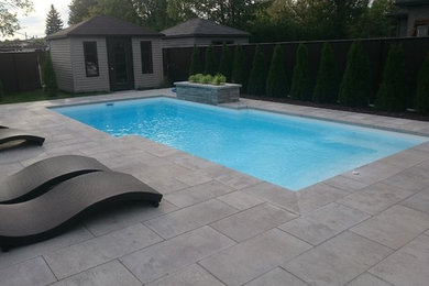 Example of a trendy backyard concrete paver and rectangular pool fountain design in Montreal