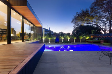 Ejemplo de piscina contemporánea grande rectangular en patio trasero con adoquines de hormigón