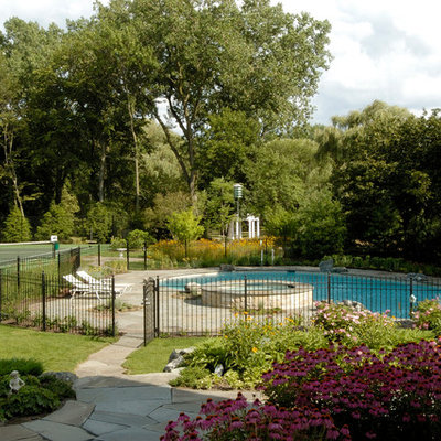 Large mountain style backyard stone and custom-shaped natural hot tub photo in Chicago
