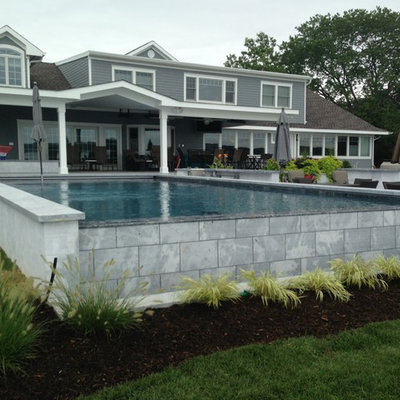 Hot tub - large contemporary backyard rectangular infinity hot tub idea in New York with decking