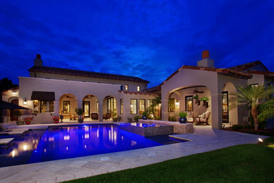 Example of a large tuscan backyard stone and rectangular hot tub design in Orlando