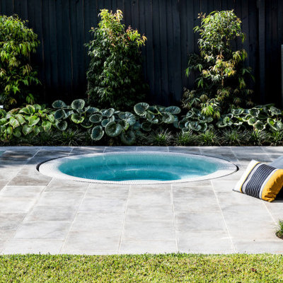 Example of a mid-sized minimalist backyard stone and custom-shaped pool landscaping design in Melbourne