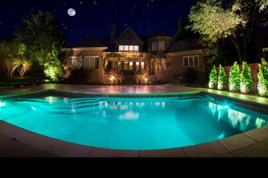 Ejemplo de piscina alargada clásica de tamaño medio rectangular en patio trasero con losas de hormigón