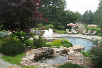Diseño de piscinas y jacuzzis alargados tradicionales grandes a medida en patio trasero con adoquines de piedra natural