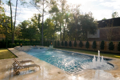 Ejemplo de piscina con fuente minimalista grande rectangular con suelo de baldosas