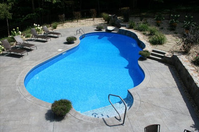 Foto de piscina con fuente grande a medida en patio trasero con adoquines de piedra natural