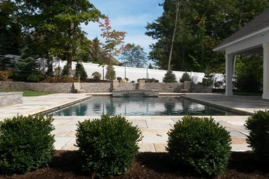 Example of a trendy backyard stone and rectangular pool design in New York
