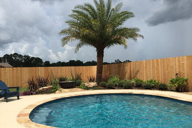 Example of a mid-sized backyard concrete and custom-shaped natural pool design in New Orleans