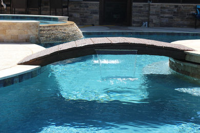 Imagen de piscina con fuente natural rural grande a medida en patio trasero
