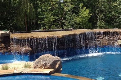 Large mountain style backyard stone and custom-shaped pool fountain photo in Kansas City