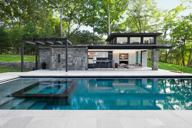 Trendy concrete paver and rectangular hot tub photo in New York