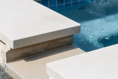 Ejemplo de piscina con fuente minimalista a medida en patio trasero