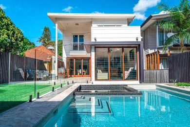 Medium sized modern back rectangular above ground hot tub in Brisbane with tiled flooring.