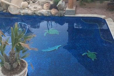 Diseño de piscina con tobogán natural de estilo americano de tamaño medio a medida en patio trasero con adoquines de piedra natural
