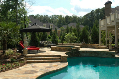 Foto de piscinas y jacuzzis clásicos renovados de tamaño medio a medida en patio trasero con adoquines de piedra natural