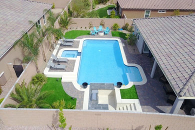 Example of a large classic backyard brick and l-shaped lap hot tub design in Las Vegas