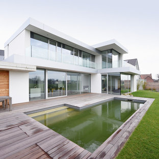 Moderner Pool hinter dem Haus in rechteckiger Form mit Dielen in Sonstige