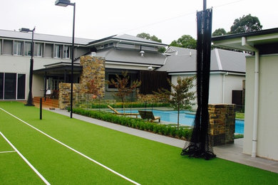 Modelo de casa de la piscina y piscina alargada contemporánea de tamaño medio rectangular en patio trasero con entablado