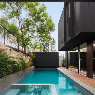Immagine di una piscina design rettangolare nel cortile laterale con pedane