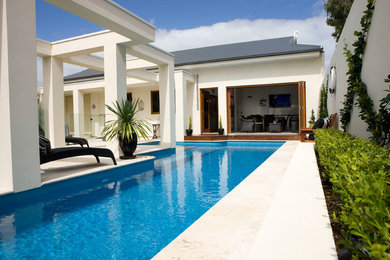 Ejemplo de piscina alargada contemporánea de tamaño medio rectangular en patio trasero