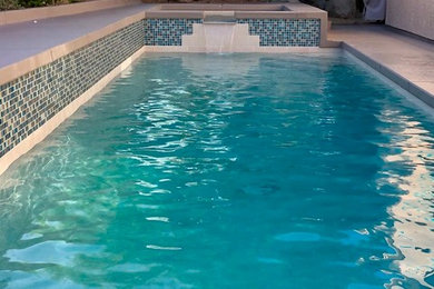 Diseño de casa de la piscina y piscina elevada moderna de tamaño medio rectangular en patio trasero con entablado