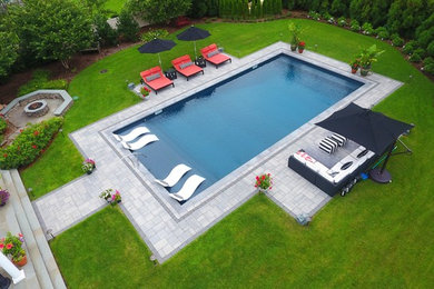 Example of a large backyard concrete paver and rectangular pool design in New York