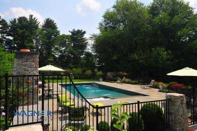 This is an example of a large traditional back rectangular lengths swimming pool in New York with a water feature and decking.